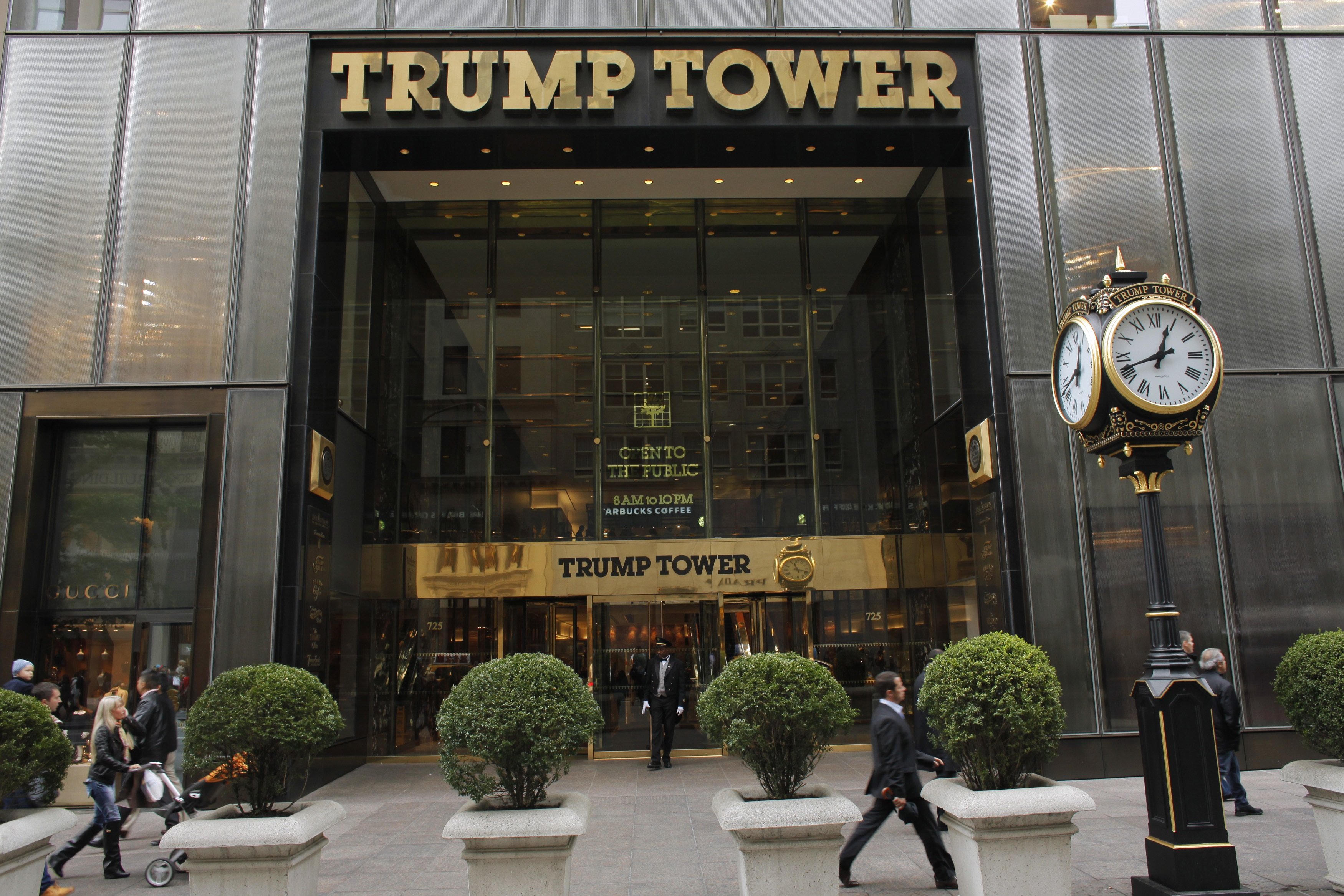 People walk in front of the Trump Tower in New York October 24, 2012. Donald Trump offered to pay $5 million to the charity of President Barack Obama's choice if Obama releases his college and passport records, the real estate mogul and television personality said on Wednesday. REUTERS/Eduardo Munoz (UNITED STATES - Tags: POLITICS BUSINESS) - RTR39J4Q